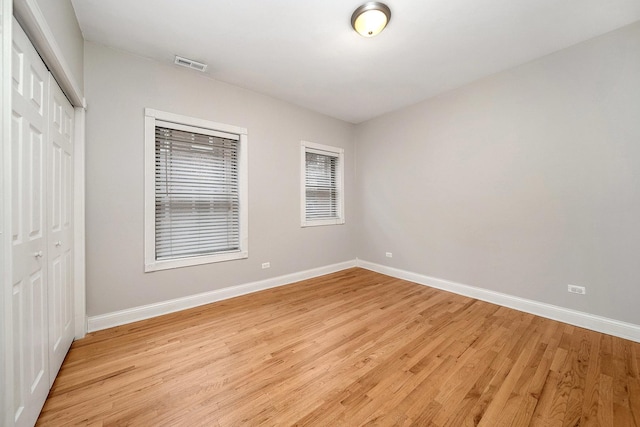 unfurnished bedroom featuring light hardwood / wood-style floors and a closet