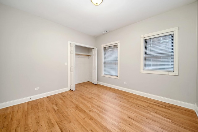 unfurnished bedroom with a closet and light wood-type flooring