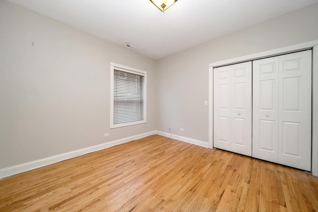 unfurnished bedroom with light hardwood / wood-style floors and a closet