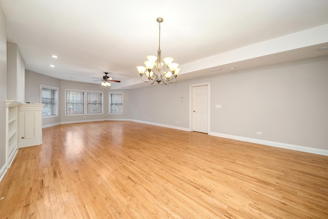 unfurnished living room with ceiling fan with notable chandelier and light hardwood / wood-style floors