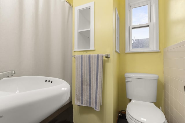 bathroom with sink, toilet, and tile walls