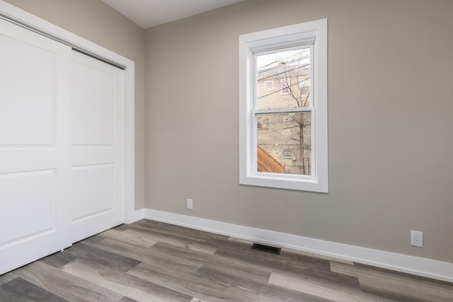 unfurnished bedroom featuring hardwood / wood-style flooring and a closet