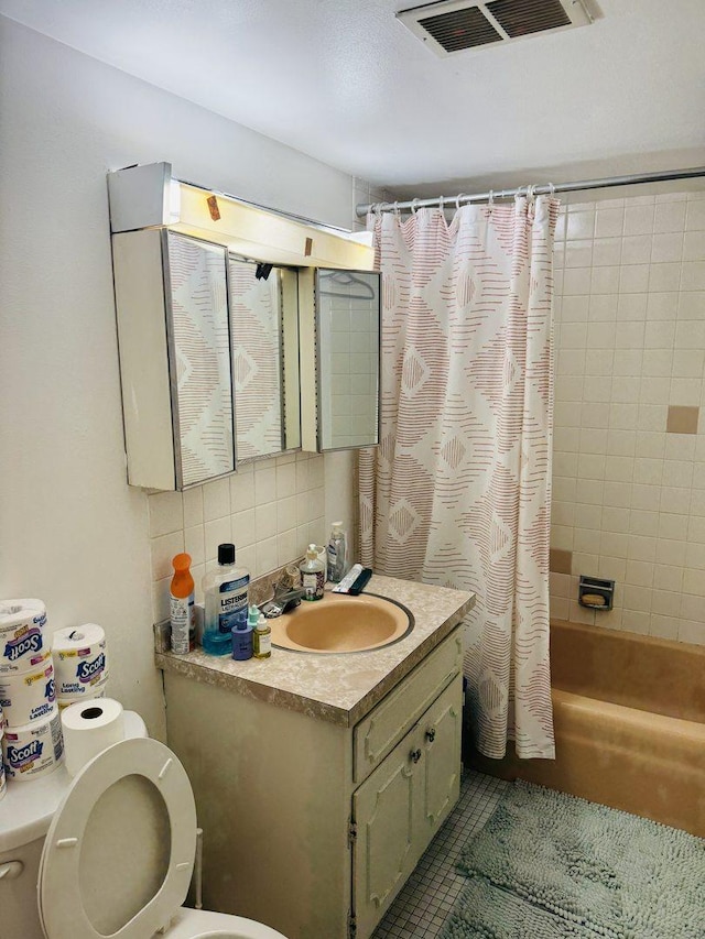 full bathroom with shower / bath combo, vanity, backsplash, tile patterned floors, and toilet