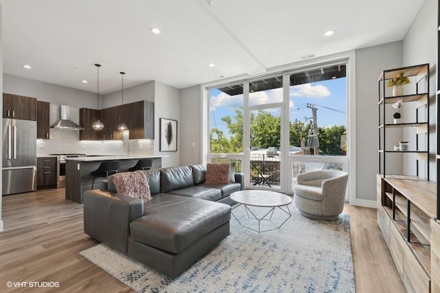 living room with light hardwood / wood-style floors and a wall of windows