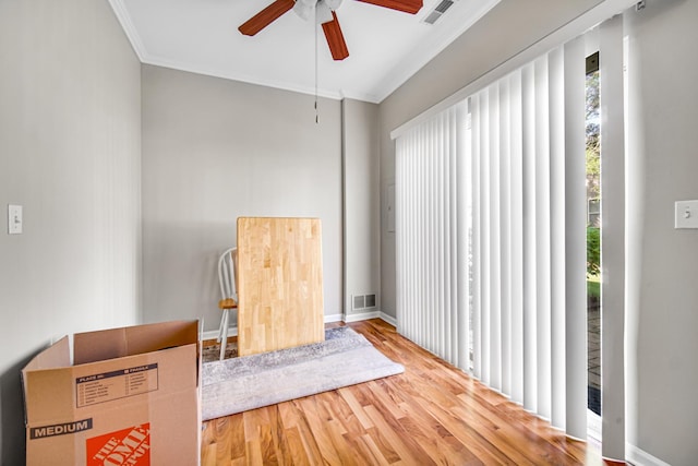 living area featuring ceiling fan, ornamental molding, and hardwood / wood-style flooring