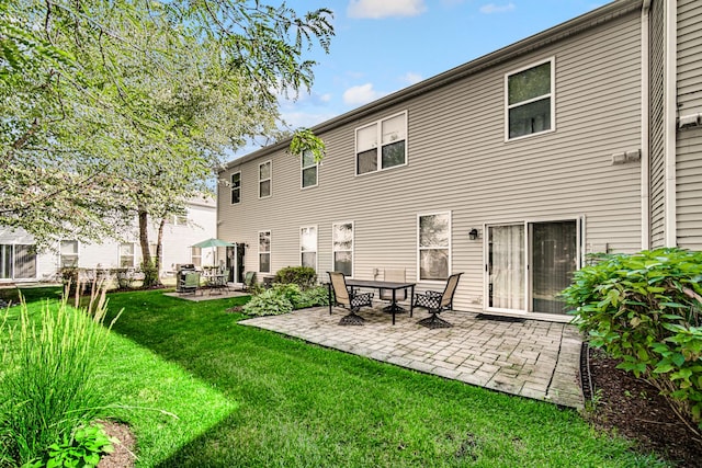 rear view of house featuring a patio, central air condition unit, and a lawn