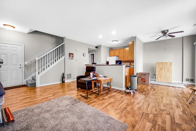 living room featuring ceiling fan, ornamental molding, and light wood-type flooring