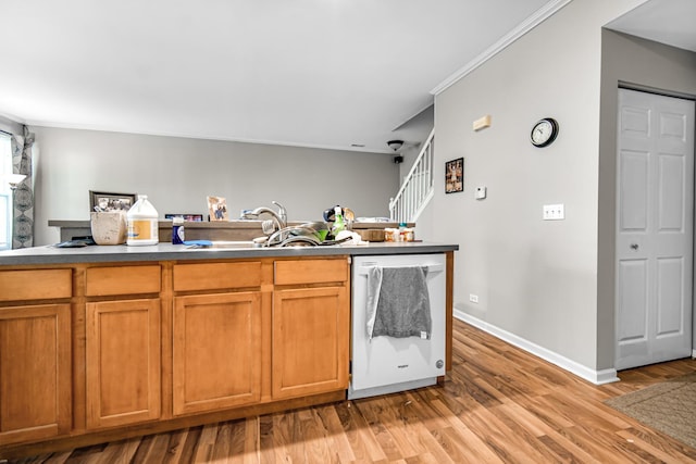 kitchen featuring sink, dishwasher, ornamental molding, and light hardwood / wood-style flooring