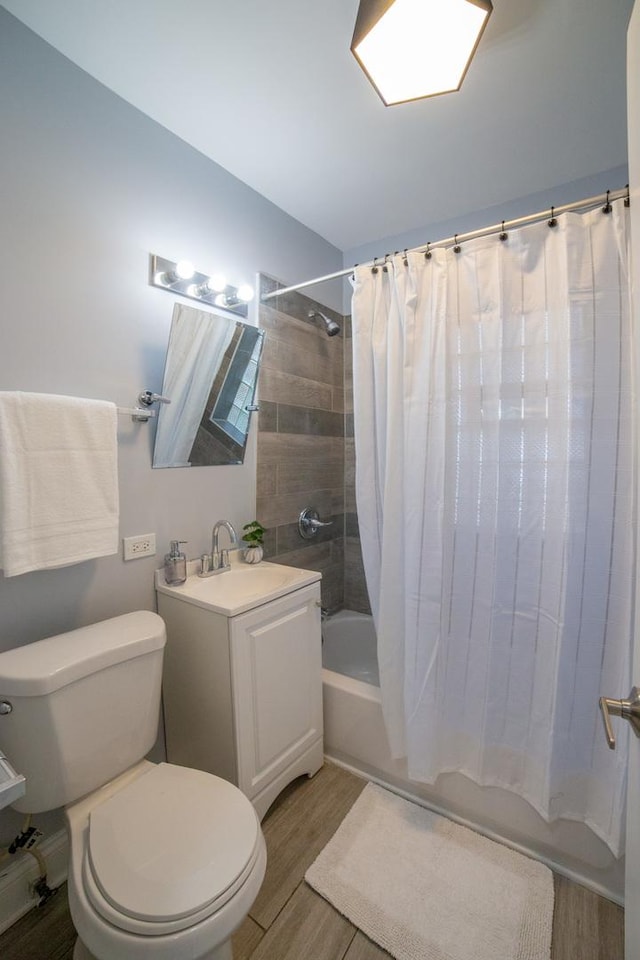 full bathroom with hardwood / wood-style flooring, vanity, toilet, and shower / tub combo