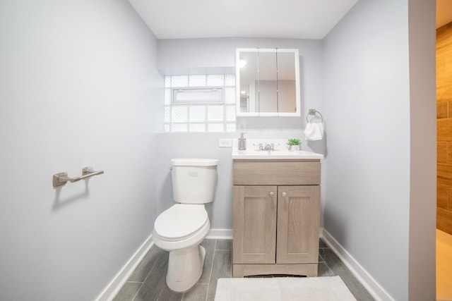 bathroom featuring wood-type flooring, vanity, and toilet