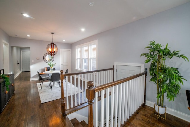 stairs featuring hardwood / wood-style flooring and a notable chandelier