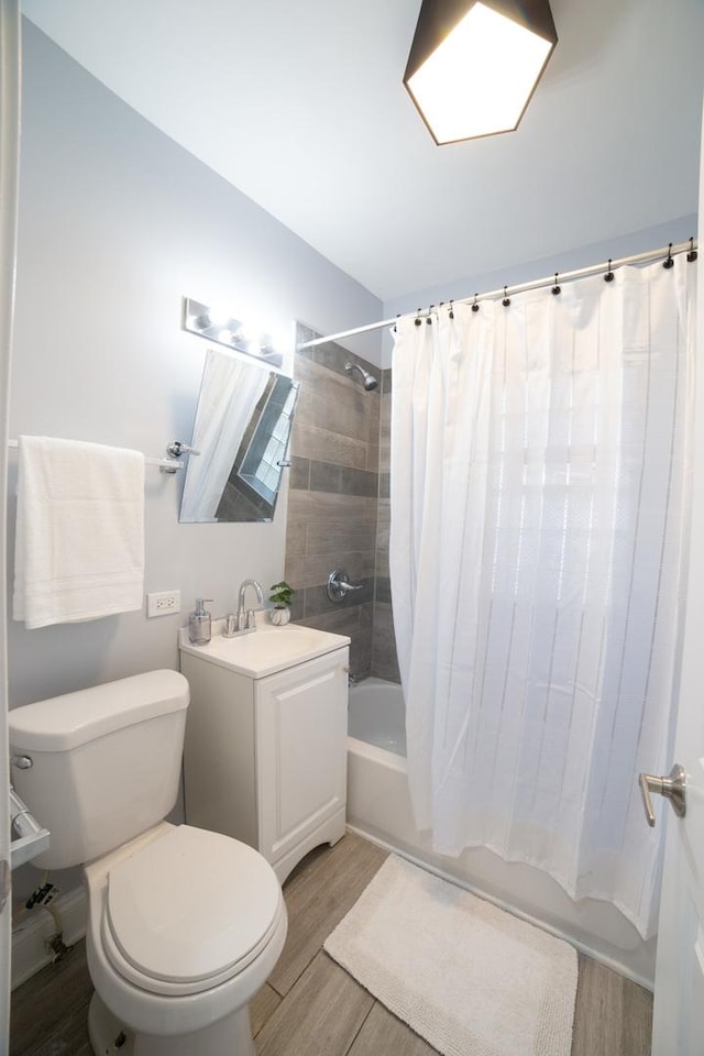 full bathroom featuring hardwood / wood-style floors, vanity, toilet, and shower / tub combo