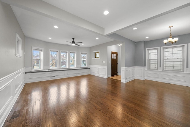 unfurnished living room featuring hardwood / wood-style floors, ceiling fan with notable chandelier, and beam ceiling