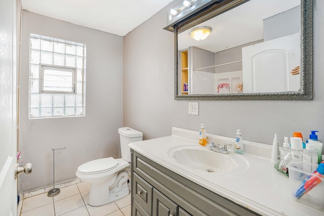 bathroom with tile patterned flooring, vanity, toilet, and walk in shower