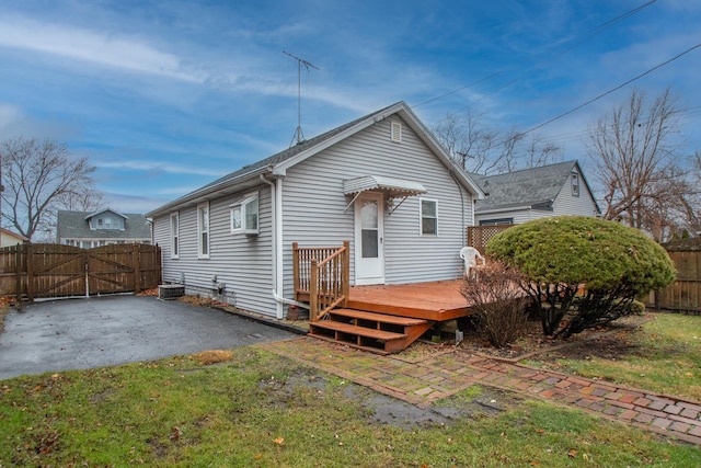 rear view of house featuring a lawn, a deck, and central air condition unit