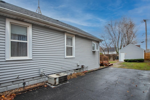 view of property exterior featuring a patio, central AC, and an outdoor structure