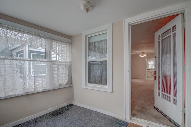 unfurnished sunroom featuring ceiling fan