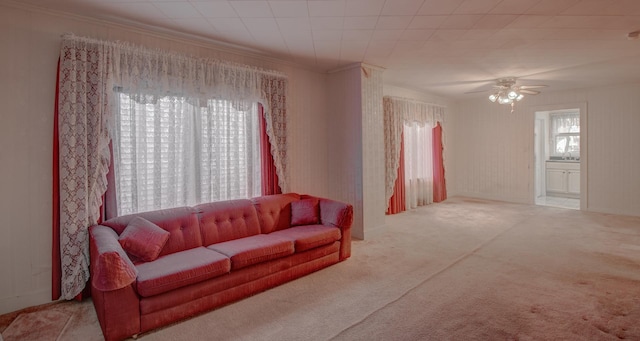 carpeted living room featuring ceiling fan and crown molding