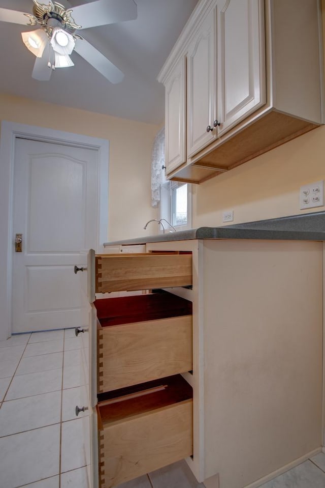 kitchen with white cabinets, ceiling fan, and light tile patterned floors