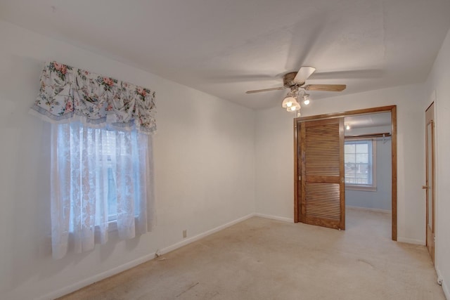 carpeted empty room featuring ceiling fan