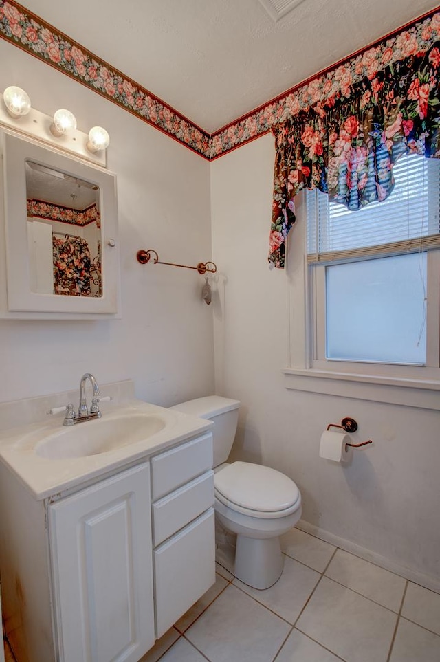 bathroom with tile patterned flooring, vanity, and toilet