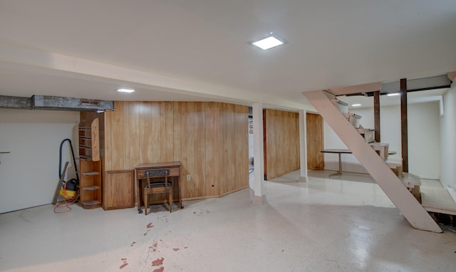 basement featuring wooden walls