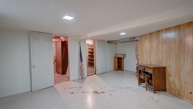 basement featuring wooden walls