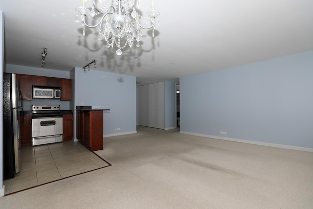 kitchen featuring stainless steel appliances, a chandelier, light colored carpet, open floor plan, and dark countertops