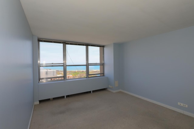 empty room featuring light carpet and baseboards