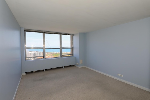 unfurnished room with light colored carpet and baseboards