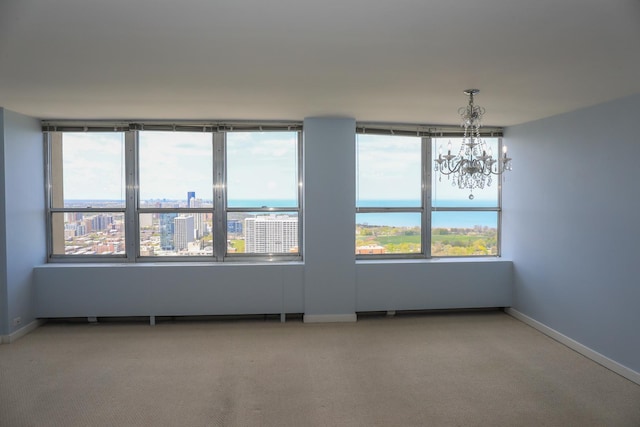 unfurnished room with a chandelier, carpet, and baseboards