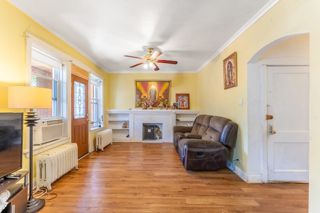 living area featuring ceiling fan, radiator heating unit, and light hardwood / wood-style flooring