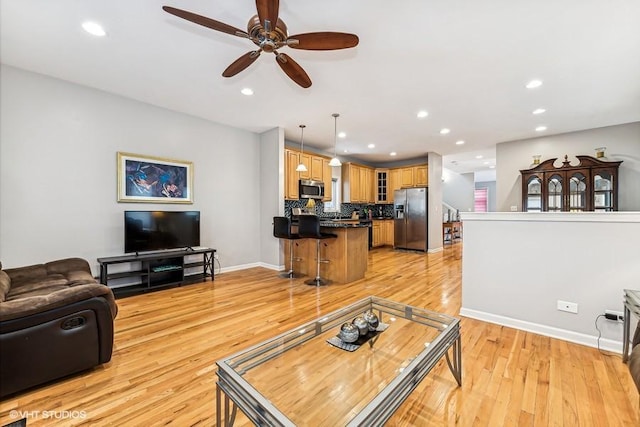 living room featuring ceiling fan and light wood-type flooring