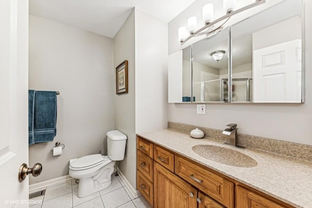 bathroom featuring toilet, a shower with door, vanity, and tile patterned floors