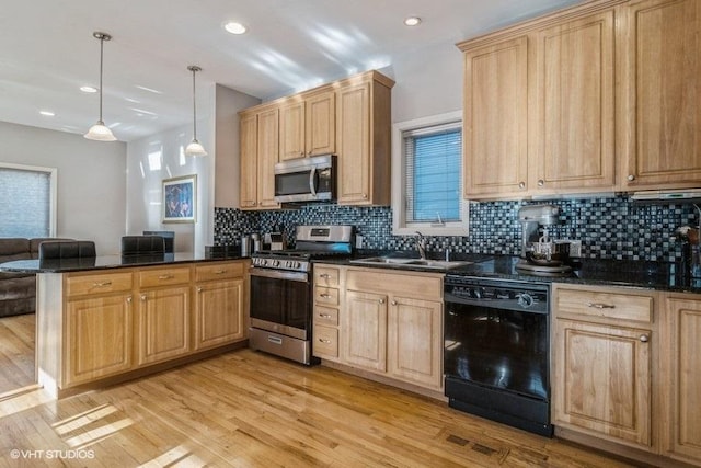 kitchen featuring kitchen peninsula, light hardwood / wood-style flooring, hanging light fixtures, stainless steel appliances, and sink