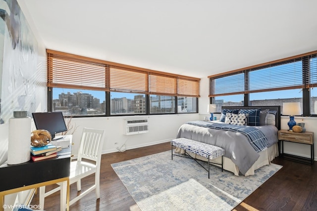 bedroom with dark hardwood / wood-style floors and a wall unit AC