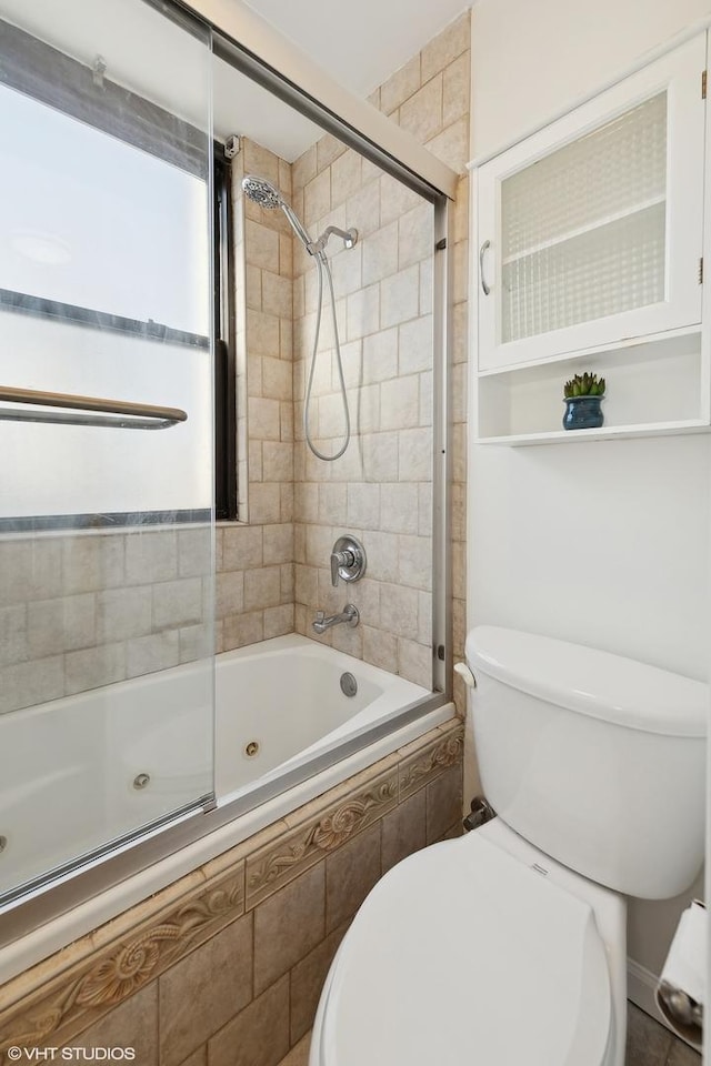 bathroom with combined bath / shower with glass door and toilet