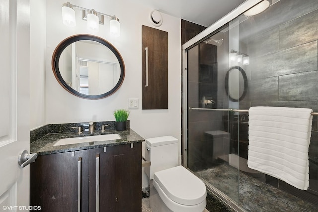 bathroom with vanity, toilet, and an enclosed shower