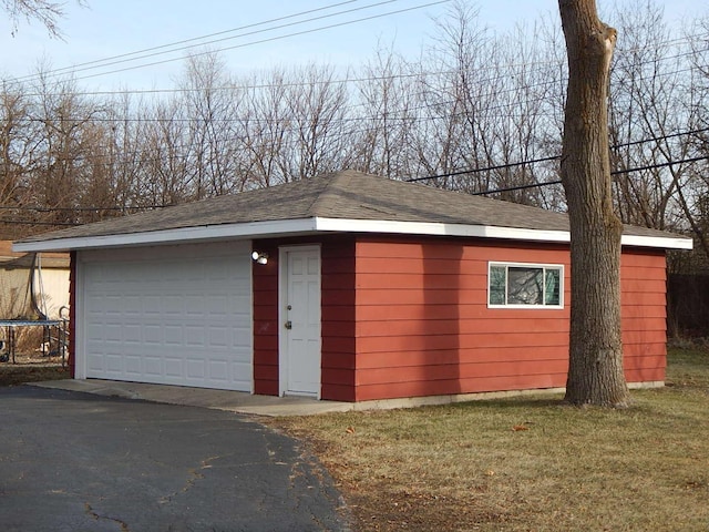 garage featuring a yard and a trampoline