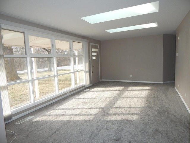 spare room featuring a skylight and carpet floors