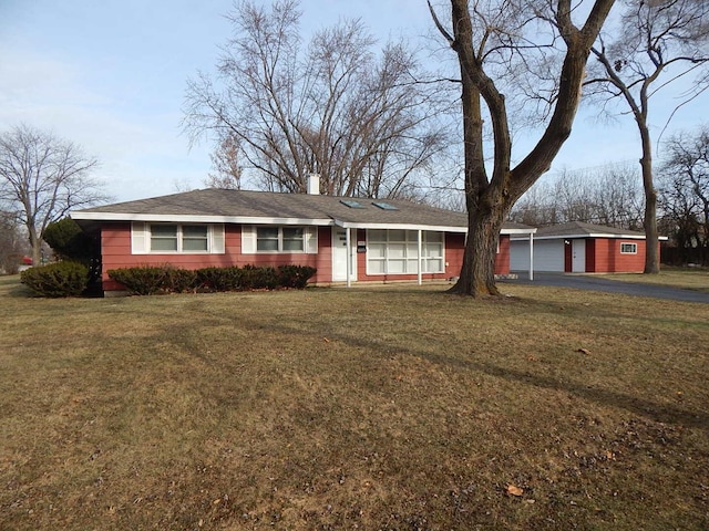 ranch-style house with a garage, a front lawn, and an outdoor structure