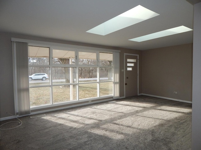 carpeted spare room featuring a skylight