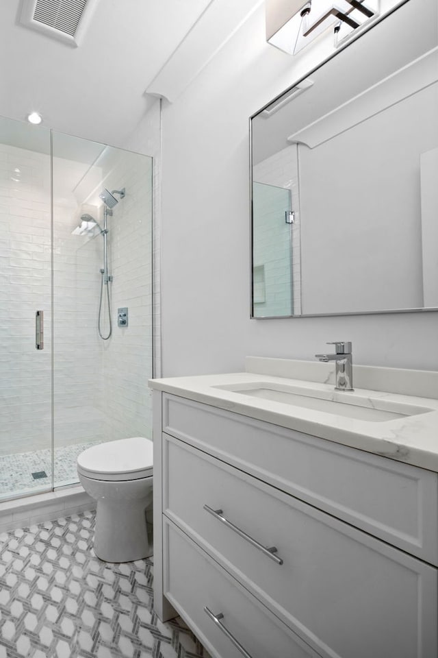 bathroom with vanity, an enclosed shower, and toilet