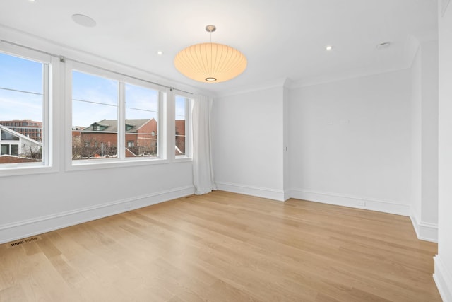 empty room with light hardwood / wood-style flooring and ornamental molding