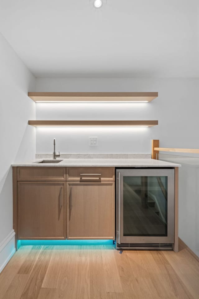 kitchen featuring light hardwood / wood-style floors, sink, and wine cooler