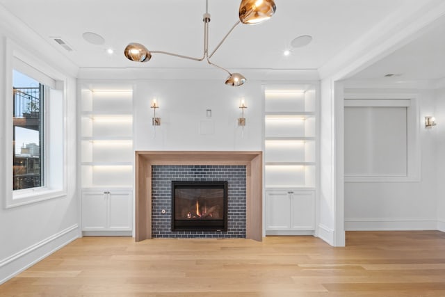 unfurnished living room with a fireplace, light hardwood / wood-style floors, and crown molding