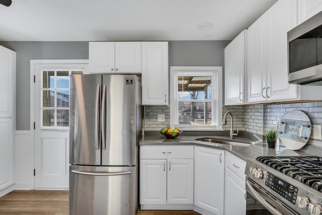 kitchen featuring white cabinets, a wealth of natural light, sink, and appliances with stainless steel finishes