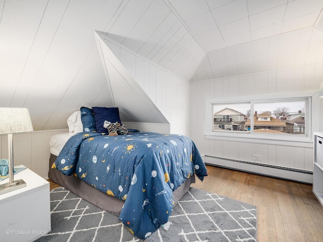 bedroom with wood walls, dark hardwood / wood-style flooring, lofted ceiling, and baseboard heating