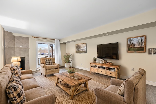 carpeted living room with a tile fireplace