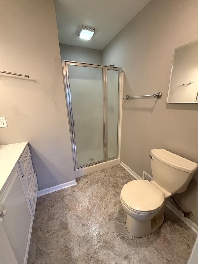 bathroom featuring vanity, an enclosed shower, and toilet